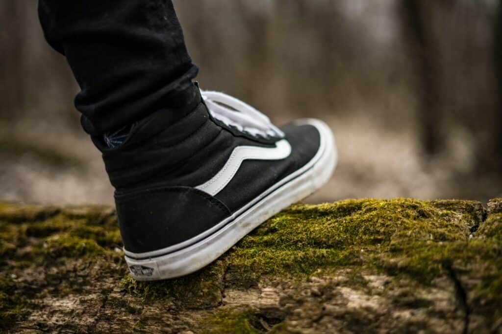 foot in dark sneakers walking in the woods